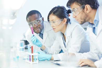 group of scientists studying reaction of some chemical