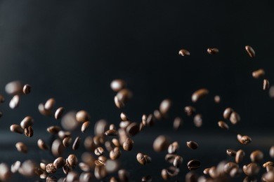 many flying coffee beans on black background