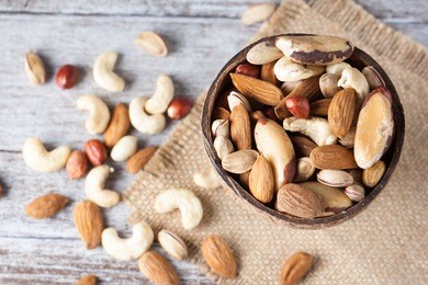 healthy mix nuts on wooden background. almonds, hazelnuts, cashews, peanuts, brazilian nuts