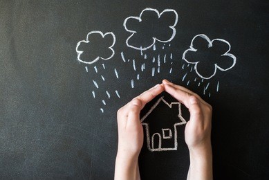 hands protects a house from the elements - rain or storm