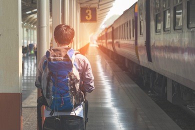 traveler man waits train on railway platform.