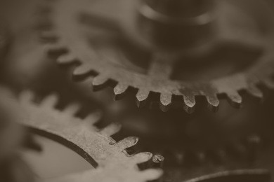 close up of cogs from the inside of a clock. black and white filter applied.