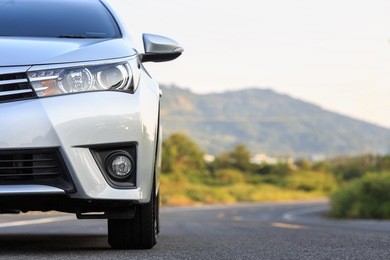 close up front of new silver car parking on the asphalt road