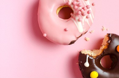 donuts with icing on pink background. sweet donuts. glazed donut.