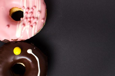 donuts with icing on black background. sweet donuts. donuts background . 