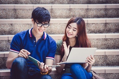 two students studying with computer notebook outdoors