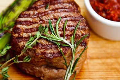 beautiful juicy well done steak with sauce on a wooden board