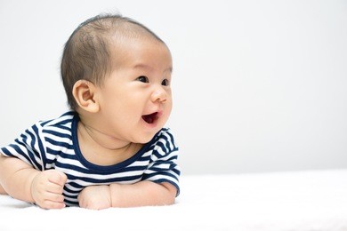 asian baby lying on stomach and raising his head