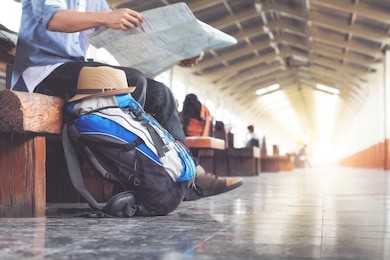 backpack and hat at the train station with a traveler. travel concept.