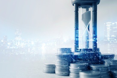 double exposure of coin money and hourglass for about time of finance concept