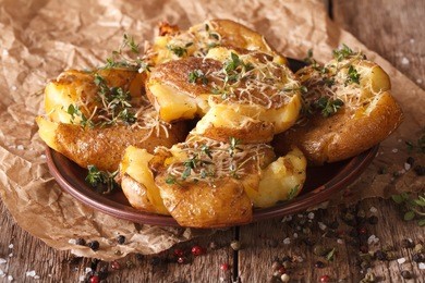 tasty crash hot potatoes with thyme and cheese close-up on a