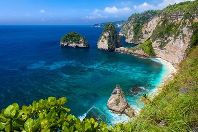 azure beach with rocky mountains and clear water of indian ocean at sunny day / a view of a cliff in bali indonesia / bali, indonesia