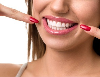 beautiful woman pointing to her teeth, concept dental care 