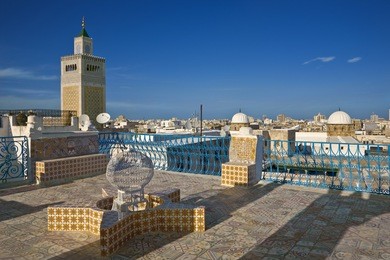 tunisia. tunis - old town (medina). terrace of palais d'orient with ornamental wall covered tiles. there is minaret zitouna mosque on left side