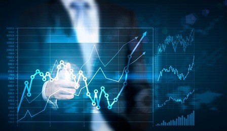 businessman hand pointing at financial chart on blue background