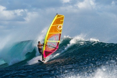 windsurfer rides among the huge tubes and waves of the indian ocean on the island of mauritius