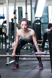 young asian girl working out in modern gym