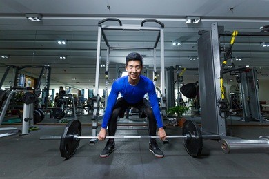 young asian man working out in modern gym
