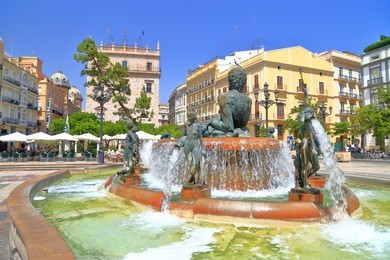 turia fountain surrounded by historical buildings in plaza de la virgen in valencia, spain