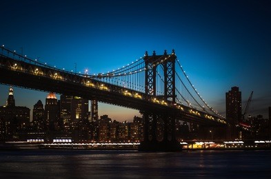 silhouette of manhattan bridge and manhattan skyline at night