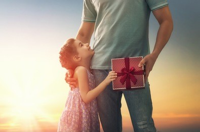 happy loving family and father's day. father and his daughter. cute child girl gives a gift to dad.