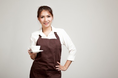 waitress or barista  in apron  holding coffee