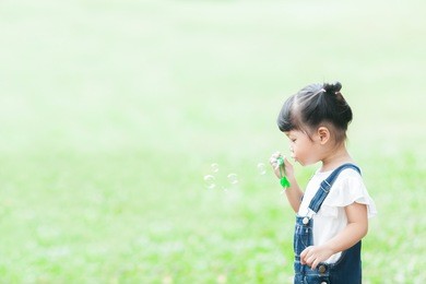 happy girl in the garden playing the bubble