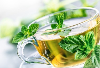 close-up cup of mint tea with herbs.