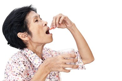 asian senior woman taking a medicine