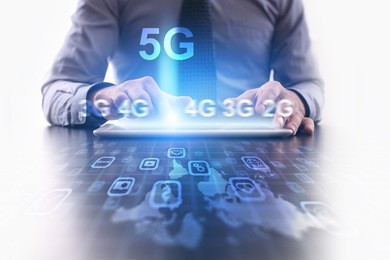 5g networking concept. businessman using futuristic tablet computer, pressing button on the touch screen and selecting 5g icon.
