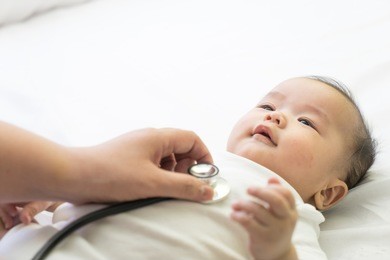 doctor exams asian newborn baby with stethoscope in the hospital