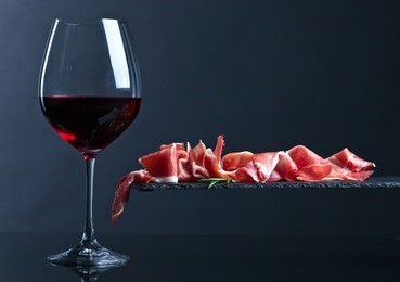 jamon with red wine on a black background