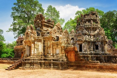 side view of entrance to ancient thommanon temple in amazing angkor, siem reap, cambodia. mysterious thommanon nestled among rainforest. blue sky in background. angkor is a popular tourist attraction.