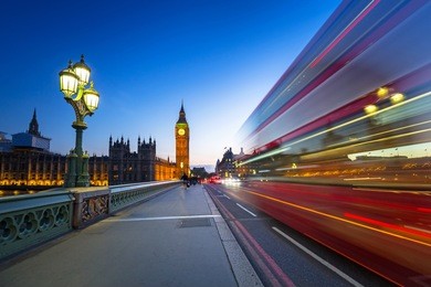 london scenery at westminter bridge with big ben and blurred red bus, uk