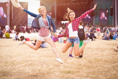 teenage girls, music festival, jumping, in front of stage
