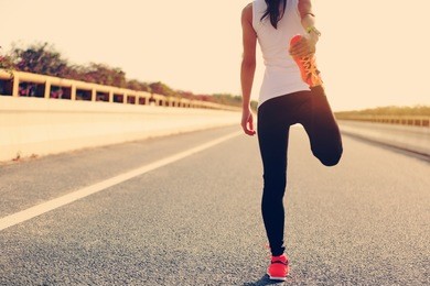 young fitness woman runner warm up on road
