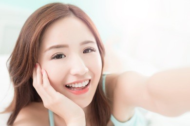 health woman smile take a selfie and she lying on the bed at home , asian girl