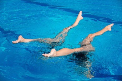 synchronized swimming duet performing in swimming pool