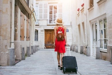 travel background, woman tourist walking with suitcase on the street in european city, tourism in europe