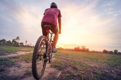 man on a bicycle in a rural area in the afternoon with sun