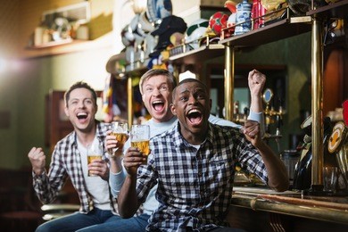 shouting fans with a beer at a bar
