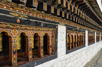 row of prayer wheels at tashichho dzong, thimphu, bhutan - the most respectful dzong in thimphu