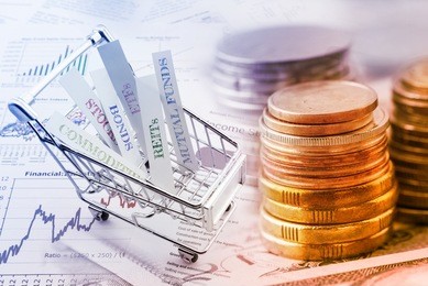 stack of coins and a trolley with various types of financial investment products i.e. stocks, commodities, bonds, reits, mutual funds, etfs. wealth management with risk diversification concept.