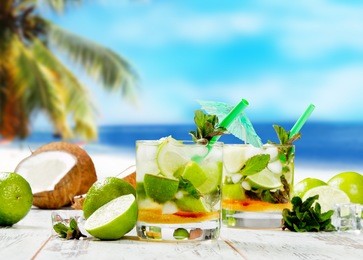 mojito lime drinks on wood with blur beach background