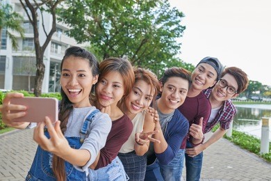 vietnamese young people standing in a row to make funny selfie