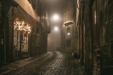 old european narrow empty street of a medieval town on a foggy evening. taken in bergamo, citta alta