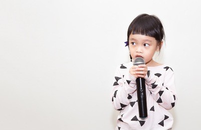 asian kid speaking in microphone