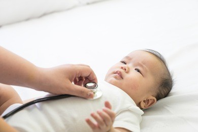 doctor exams asian newborn baby with stethoscope in the hospital