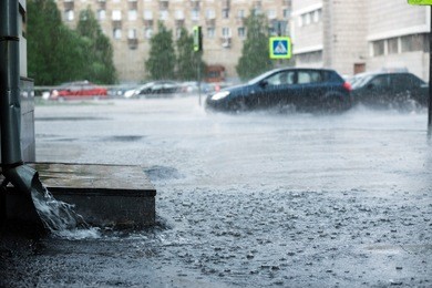 rain water flowing from metal downspout during a flood. concept of protection against heavy downpours.