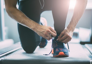 closeup portrait of a man tying shoelaces
